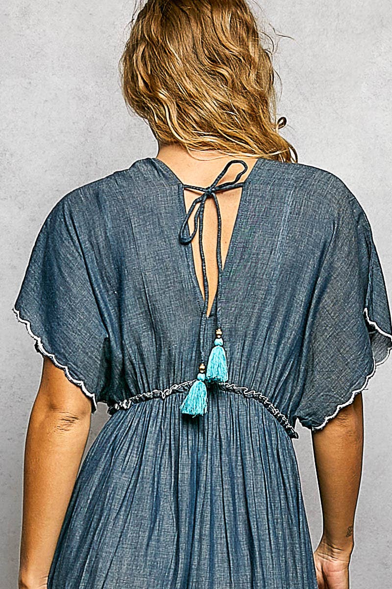 Blue dress with tassels on a gray background