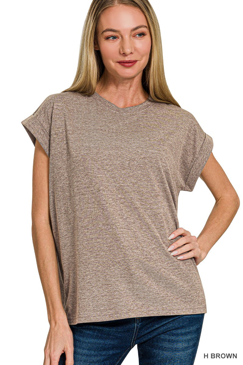 Woman wearing a brown t-shirt with folded sleeves
