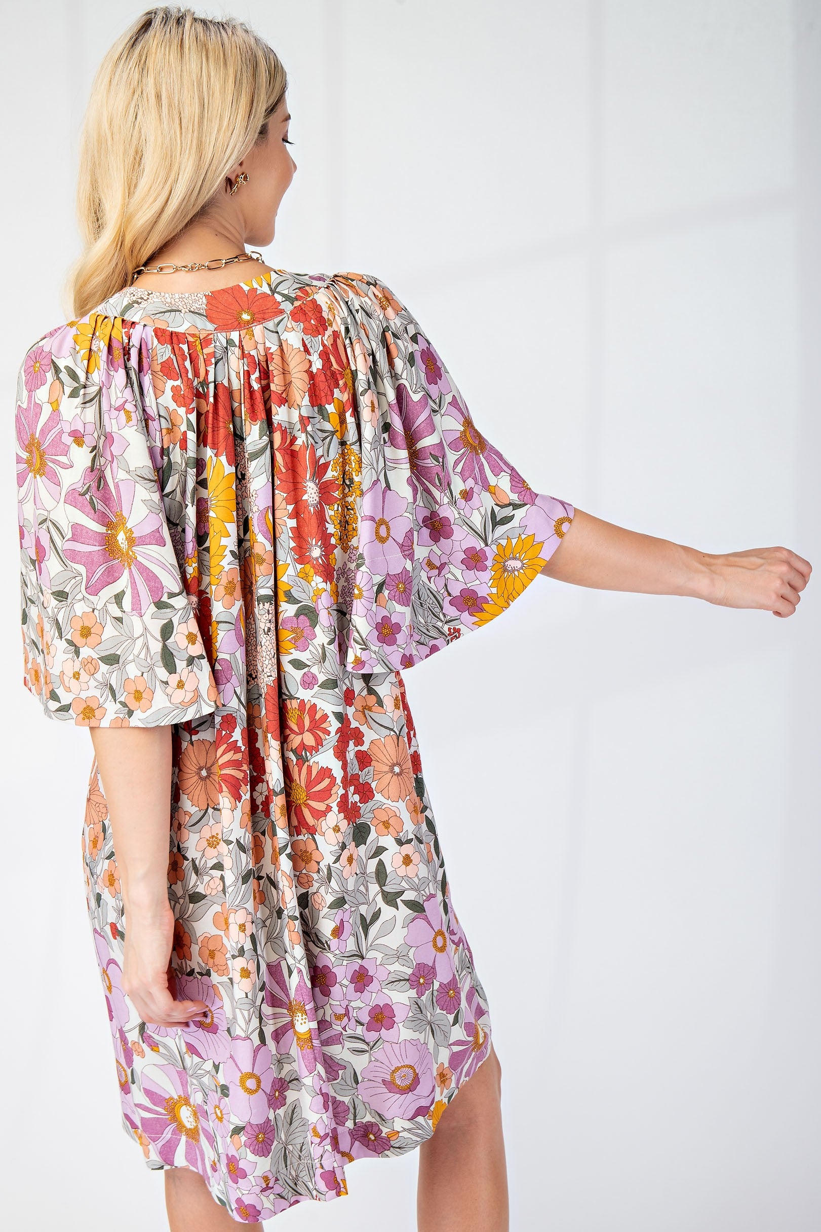 Back of woman wearing floral dress with cape sleeves