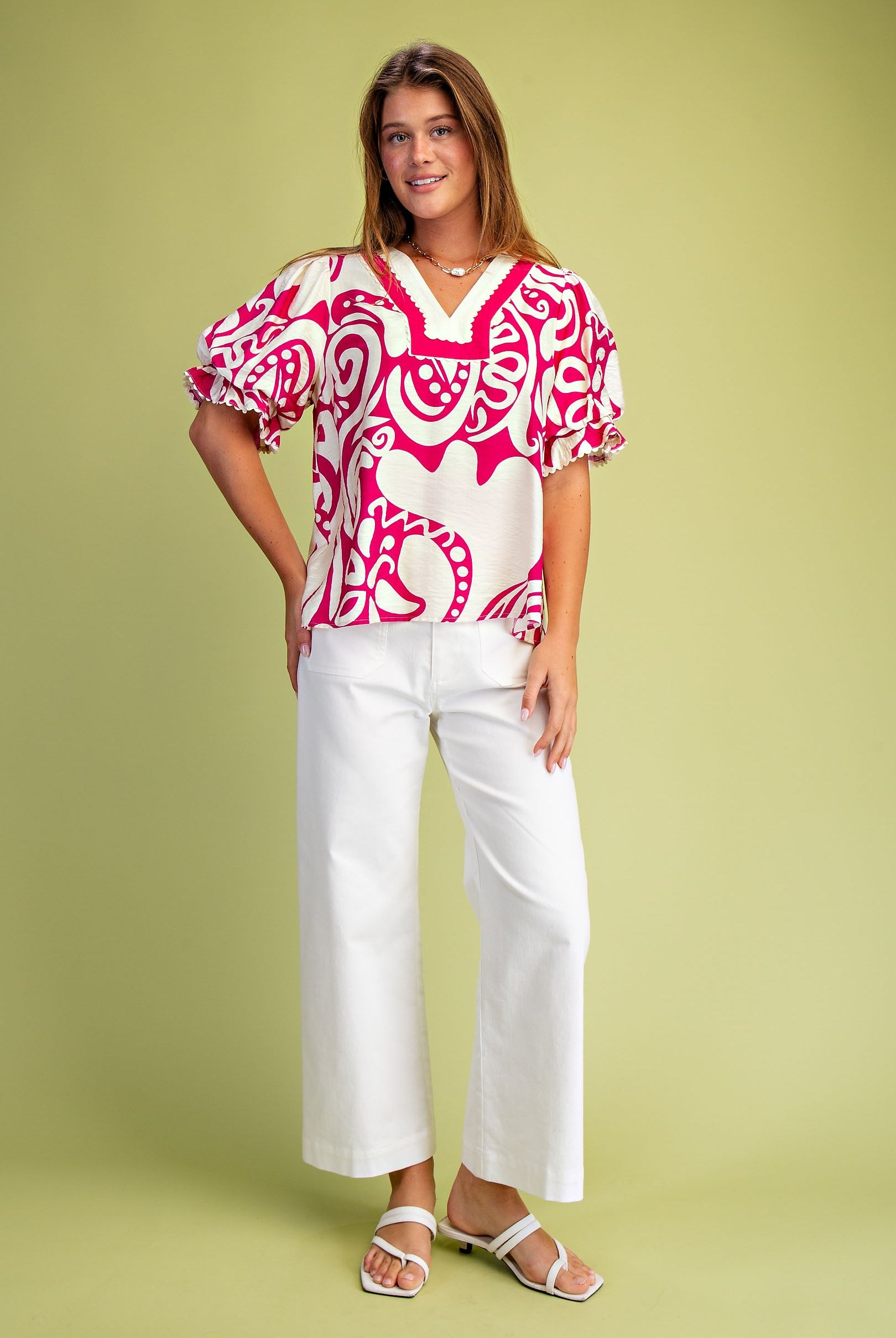 Woman wearing a pink and white patterned blouse with balloon sleeves