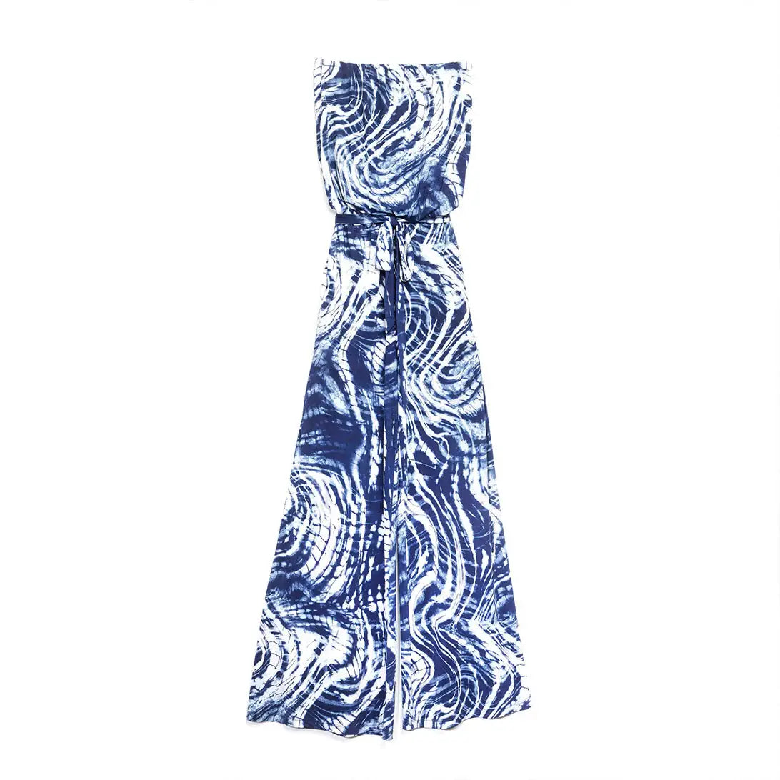 A sleeveless wrap maxi dress with a blue and white tie-dye swirl pattern, featuring a tie waist and a draped front, shown against a plain white background.