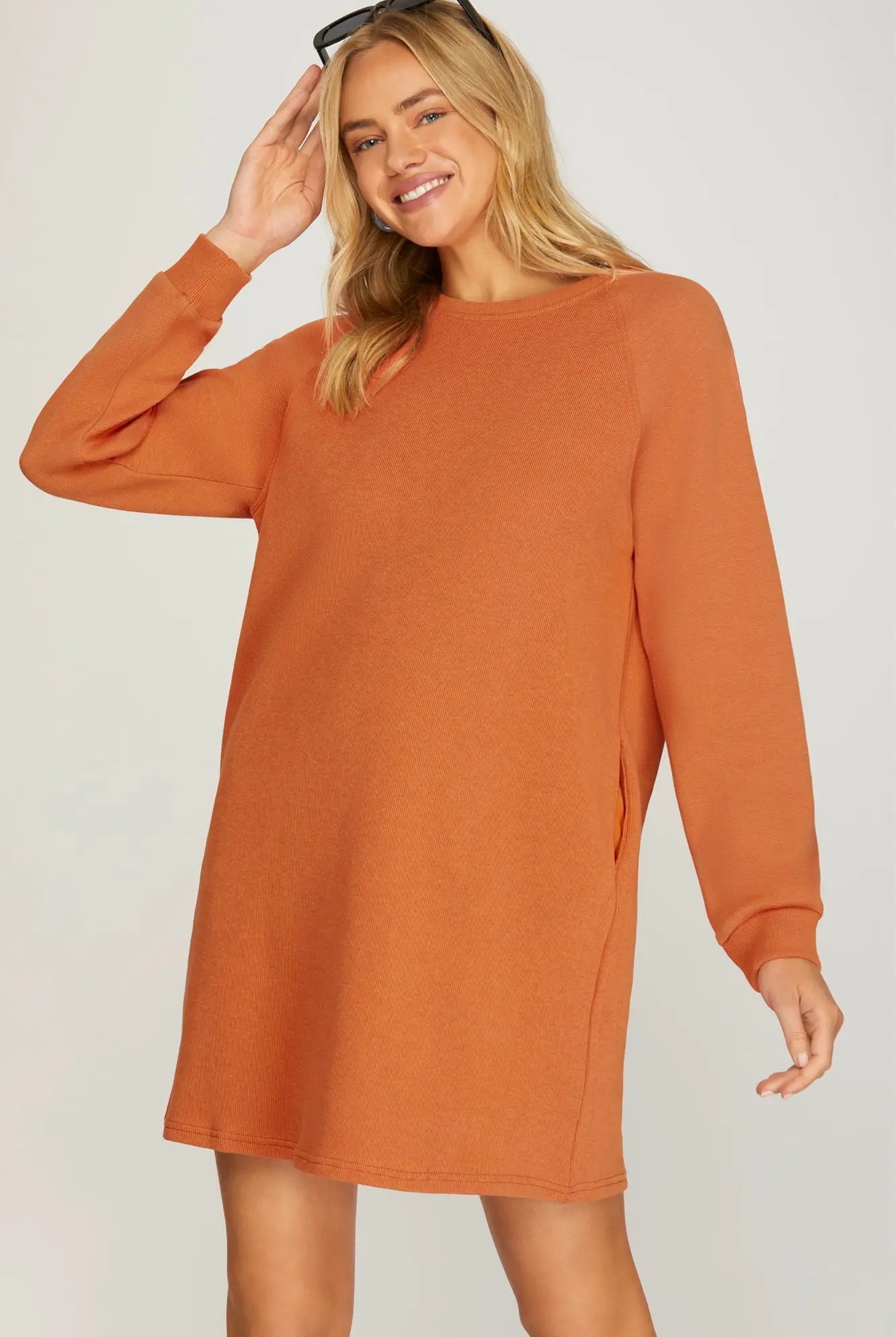 Model wearing orange knit dress