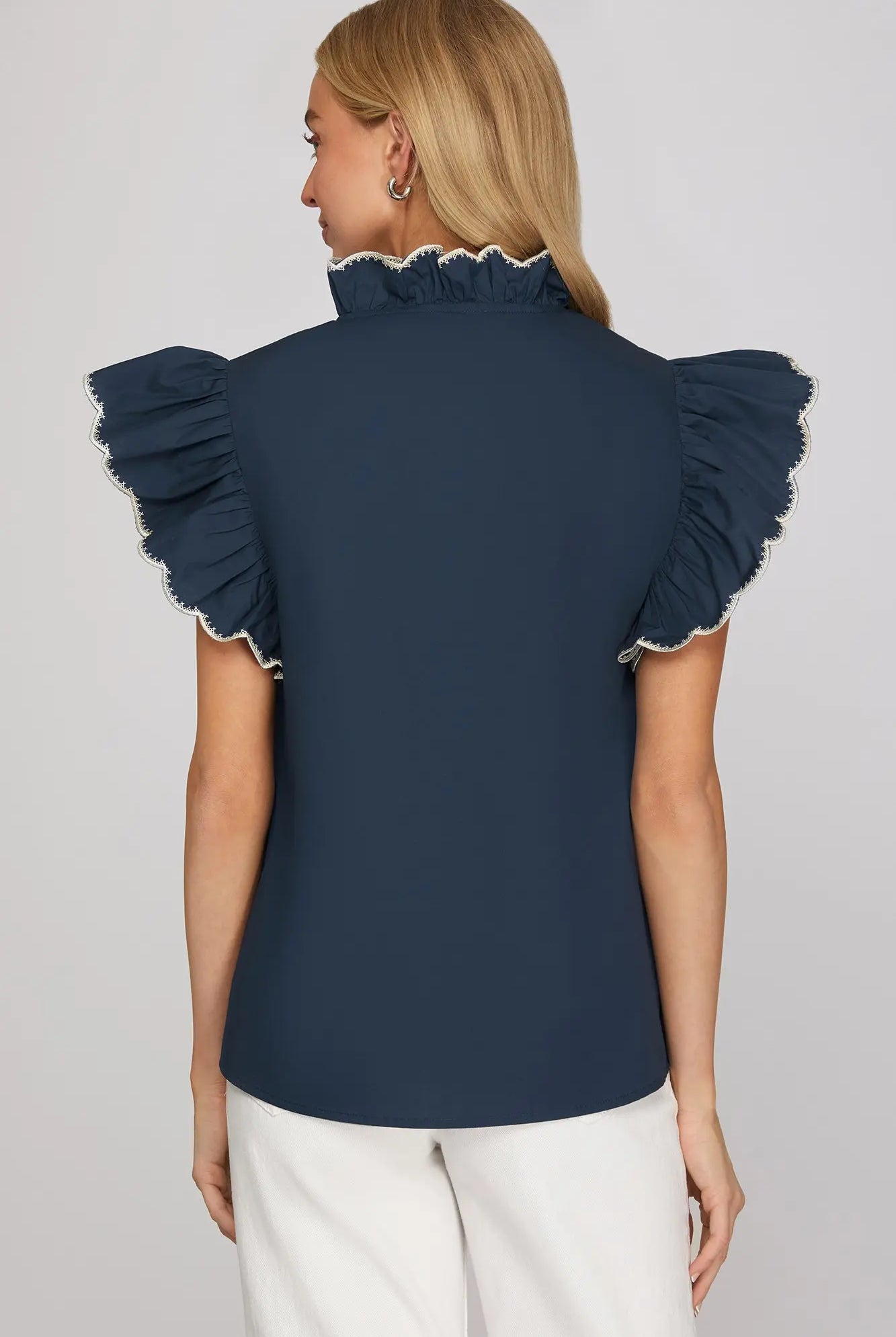 Back of woman wearing a navy blue top with ruffled sleeves