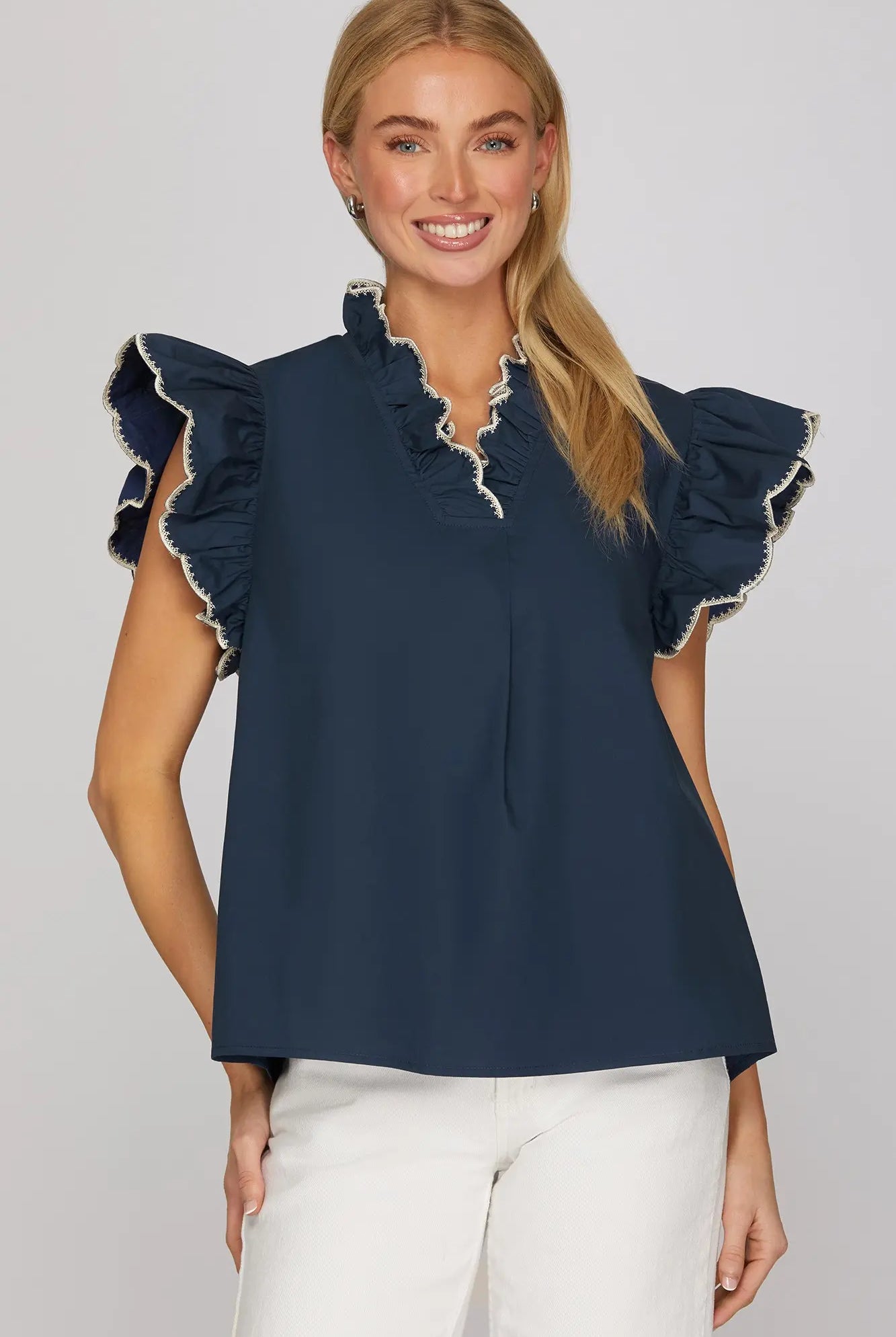 Woman wearing a navy blue top with ruffled sleeves