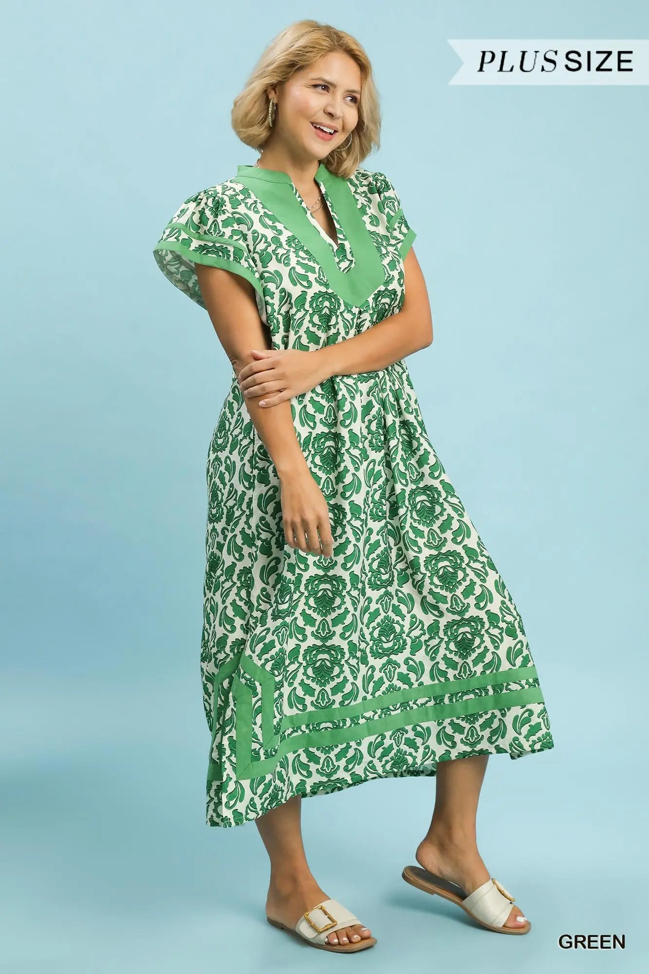 Woman wearing a green patterned dress on a blue background