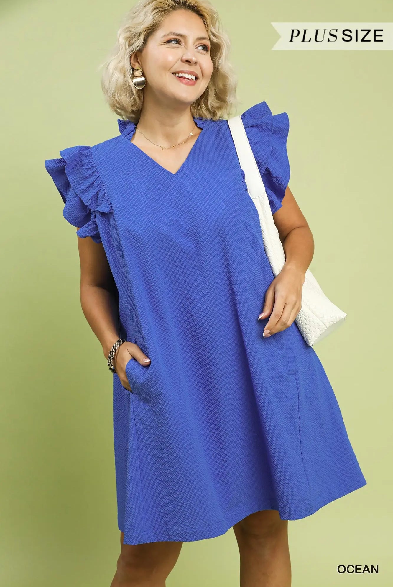 Woman wearing a blue dress with ruffled sleeves