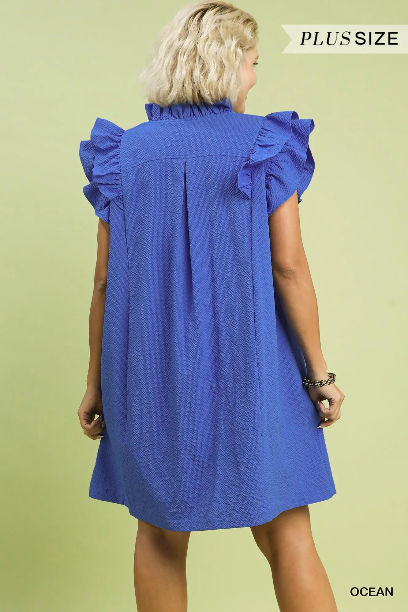Back of woman wearing a blue dress with ruffled shoulders