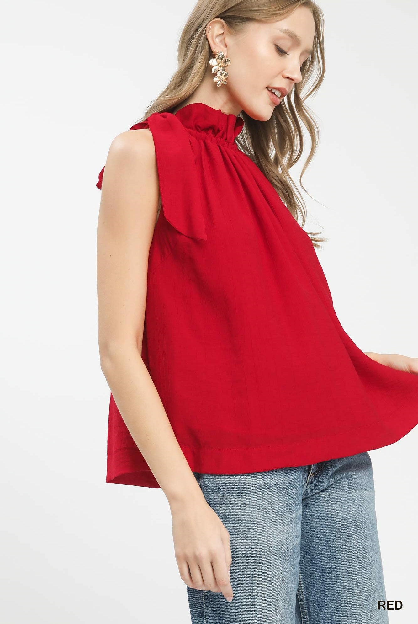 Woman wearing a red sleeveless top with a bow detail