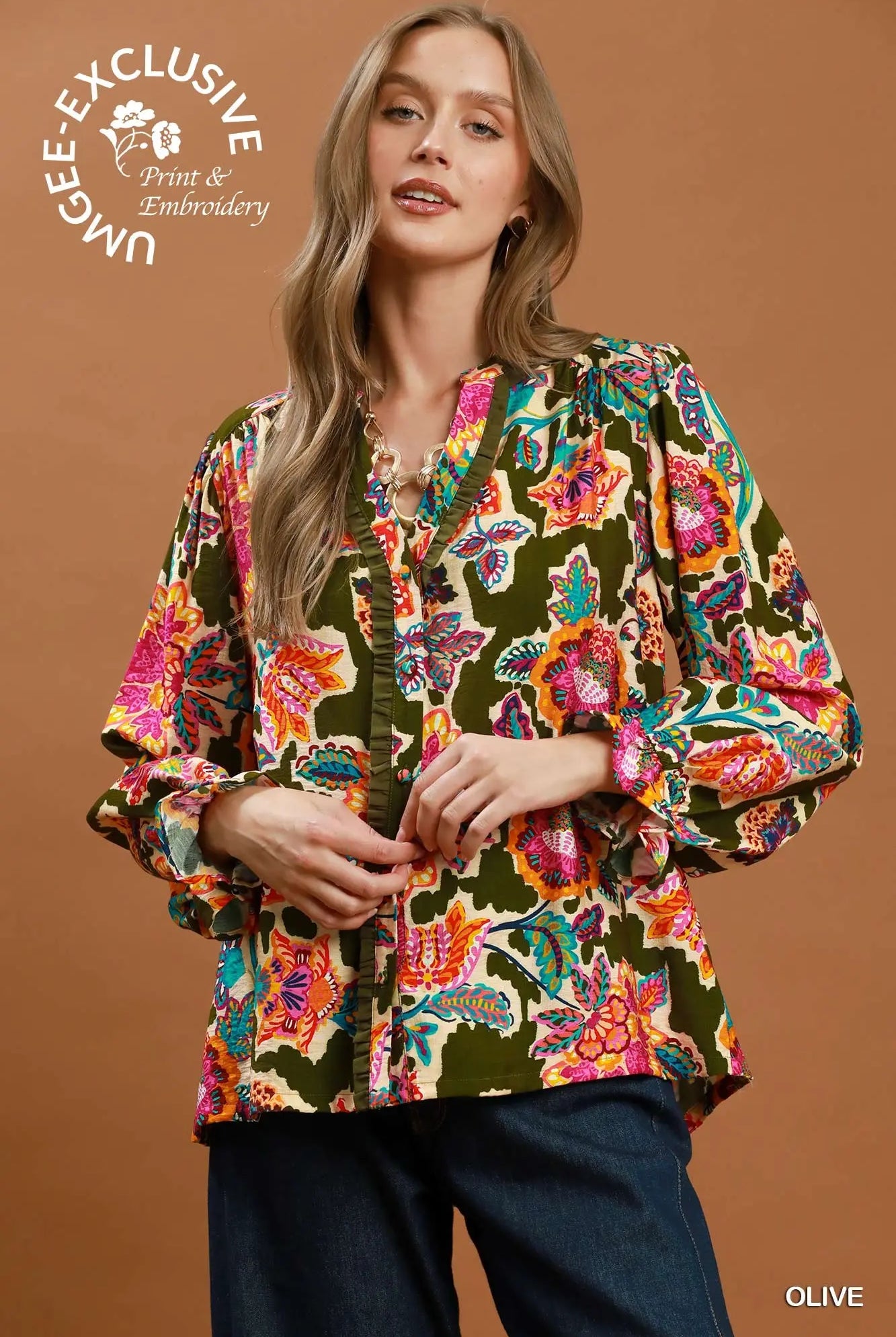Woman wearing a colorful floral blouse against a brown background