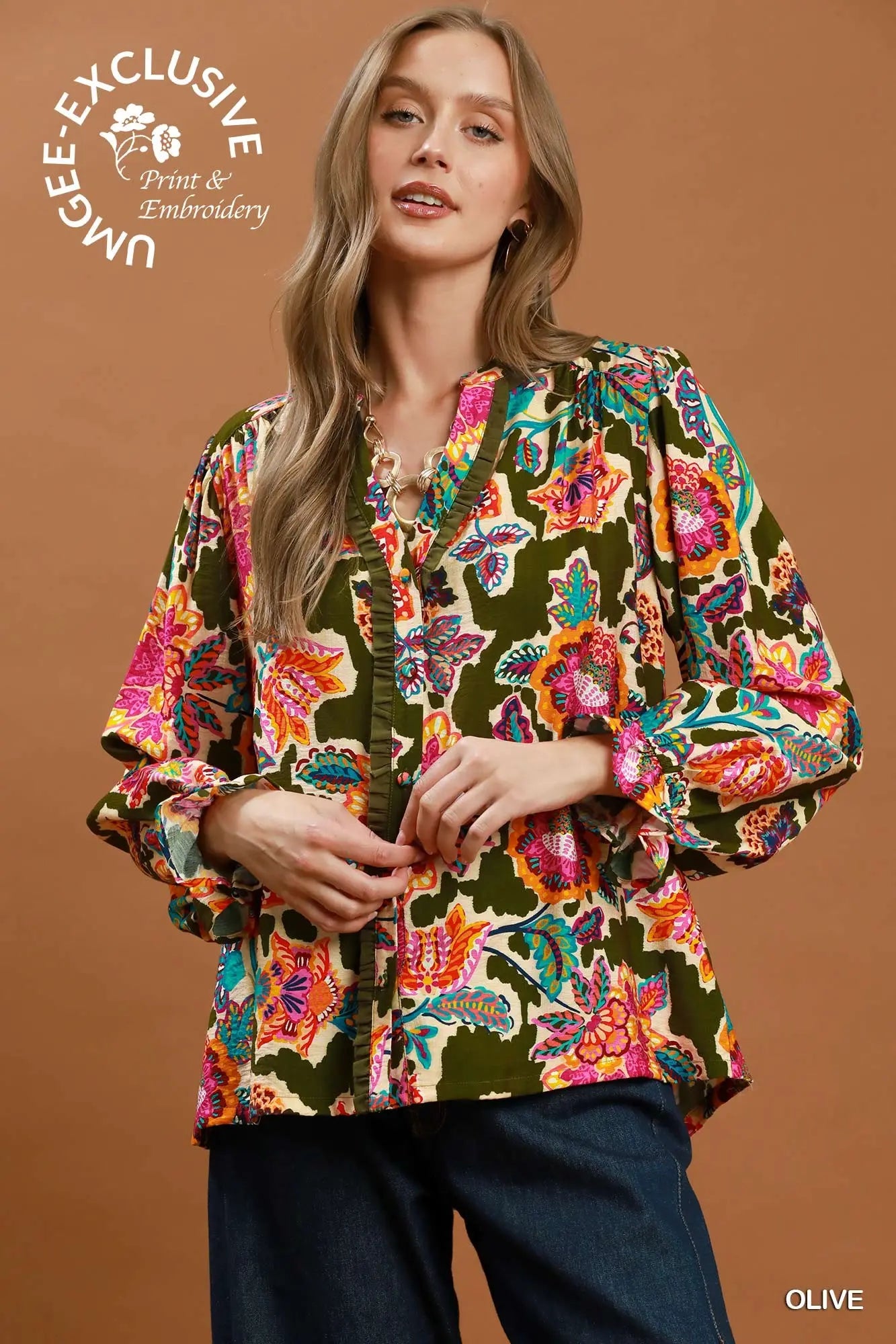 Woman wearing a colorful floral blouse against a brown background