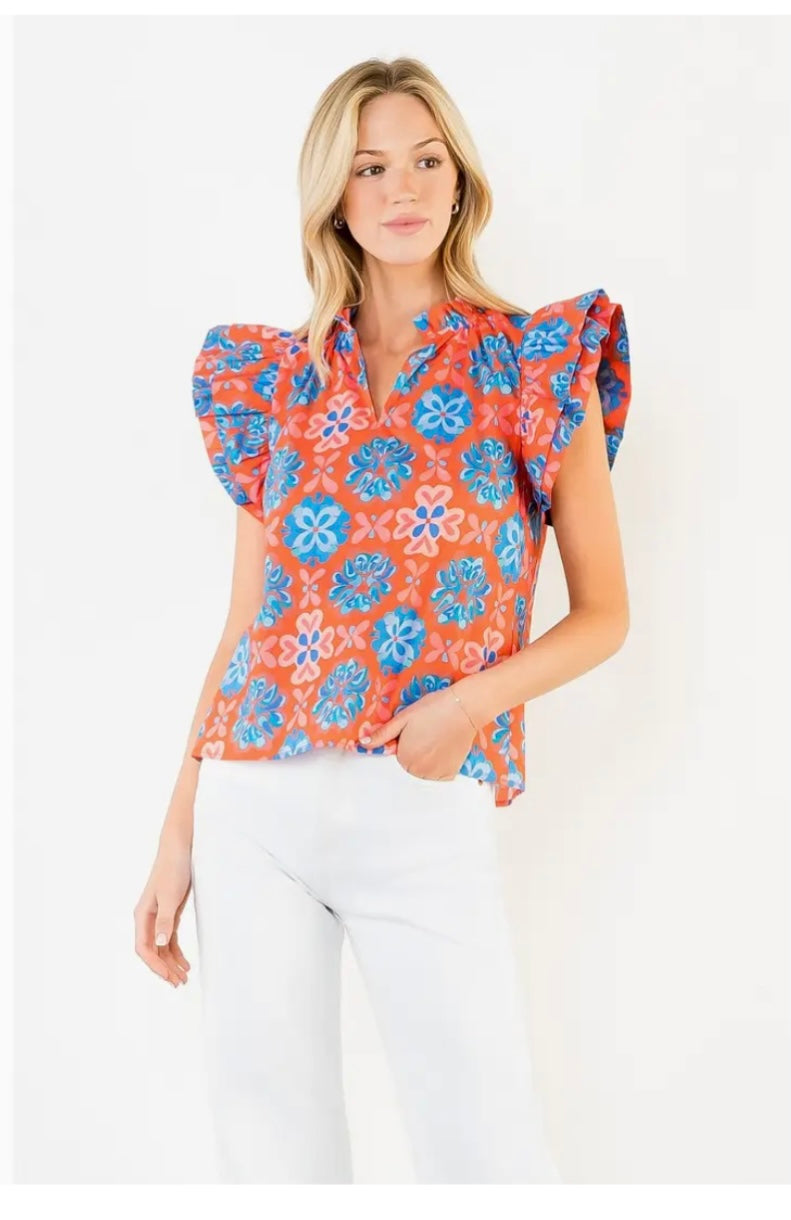 Model wearing orange printed blouse on white background