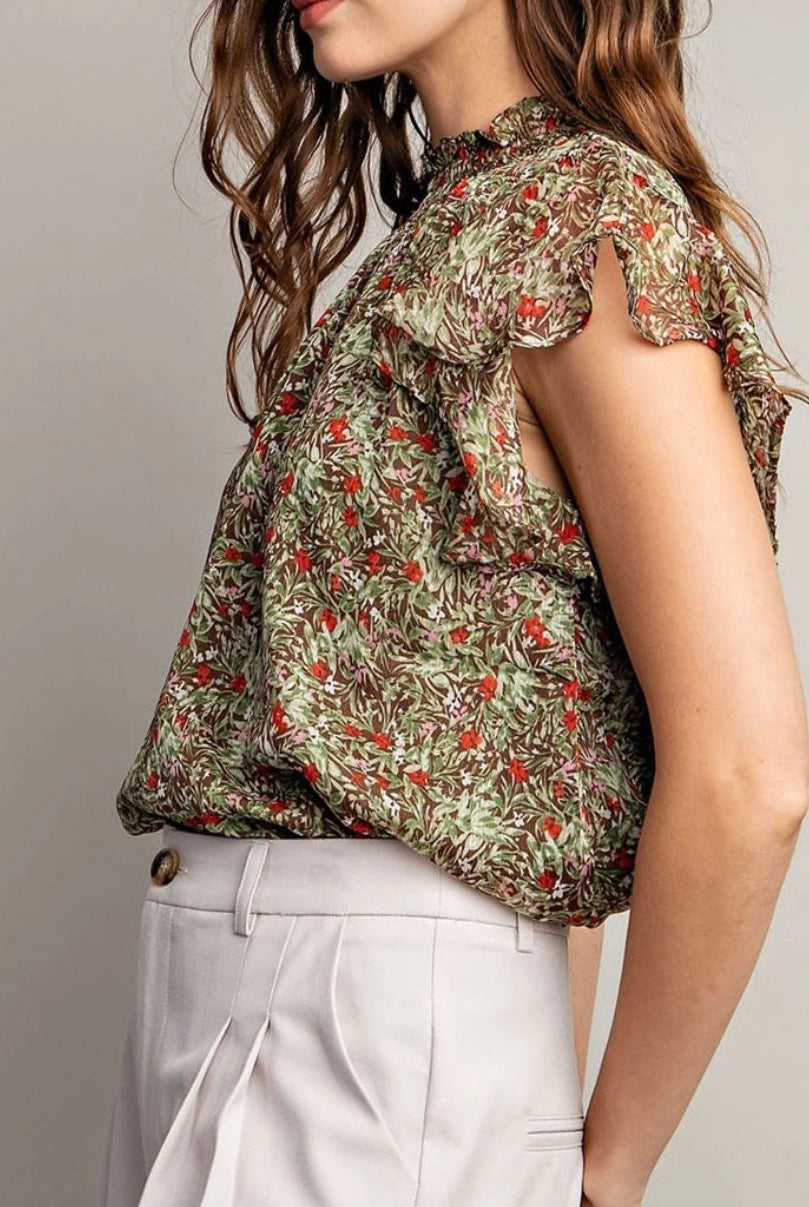 Model wearing olive floral tank with white pants