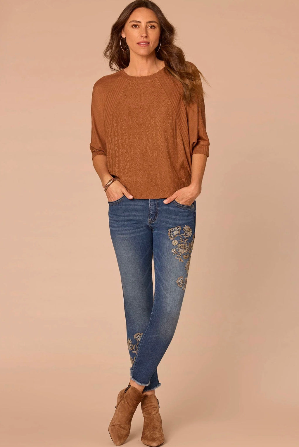 Woman wearing rust colored shirt and jeans