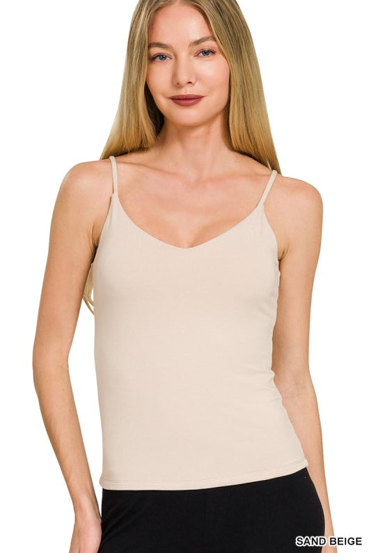 Woman wearing a beige camisole against a white background
