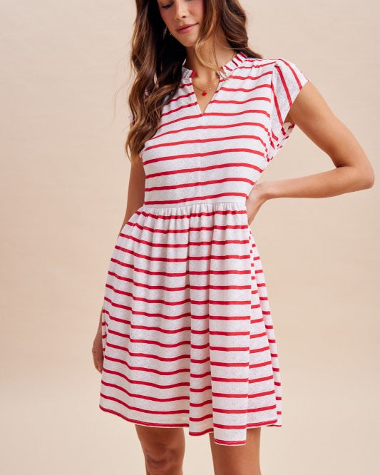 Woman wearing a red and white striped dress against a beige background