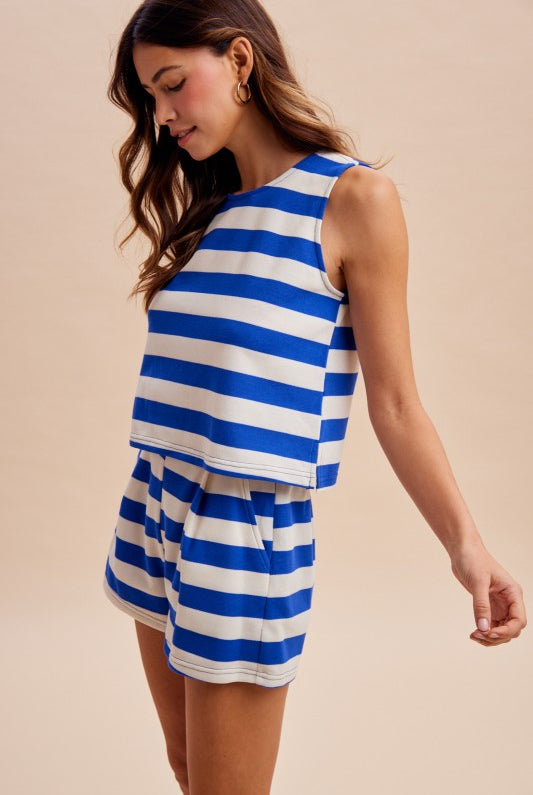 Woman wearing a blue and white striped set against a beige background