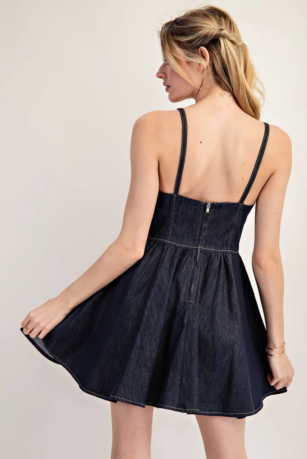 Back view of model wearing spaghetti strap, dark denim dress