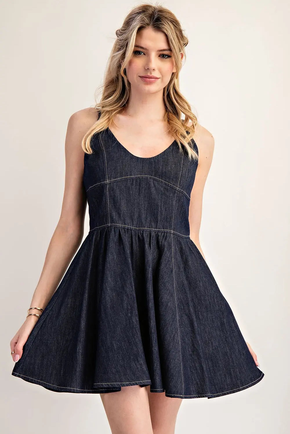 Model wearing dark denim dress with skirt flared