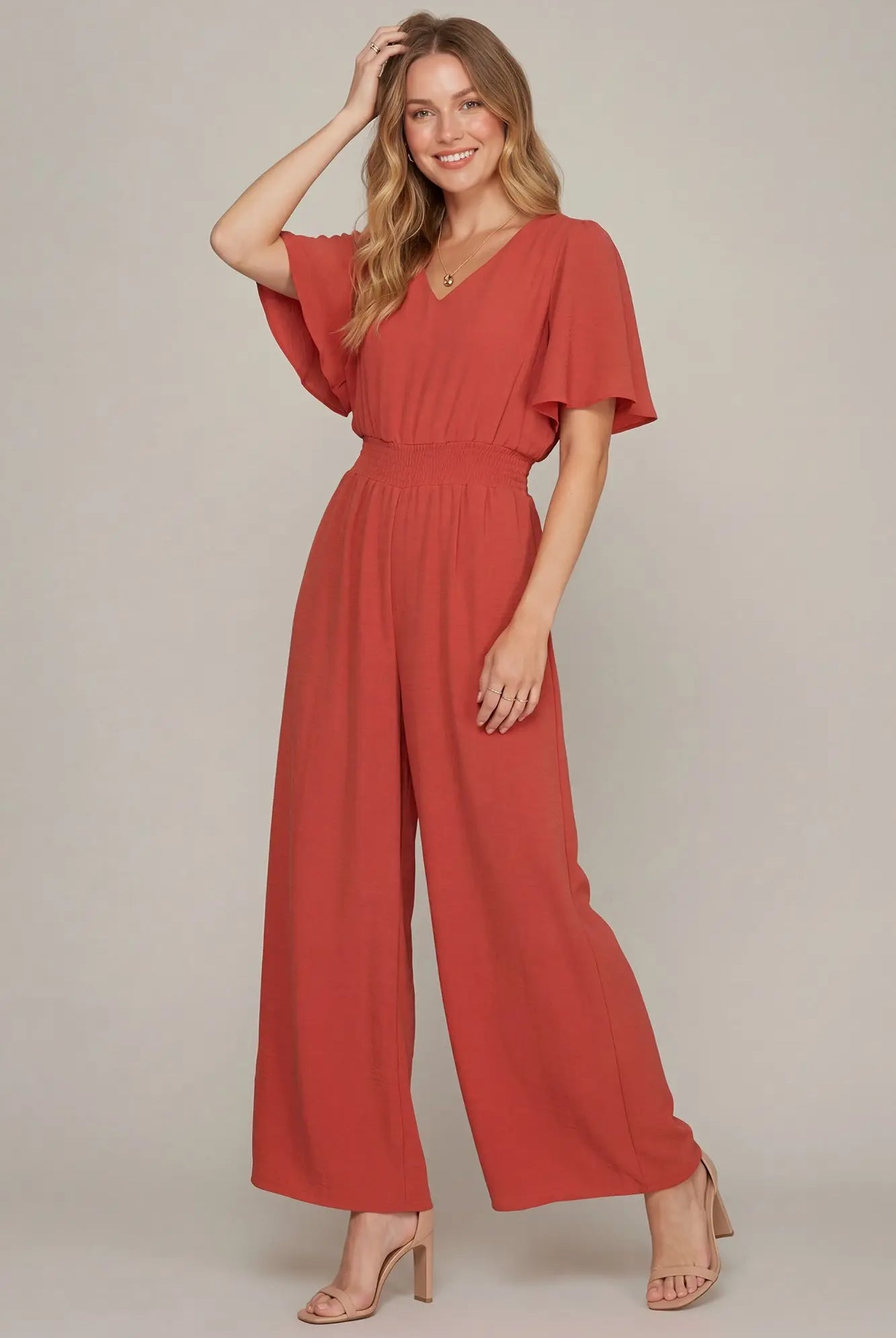 Model wearing coral flounce sleeve jumpsuit