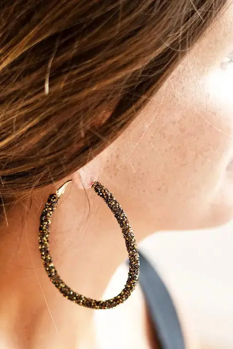 Model wearing black and gold earrings