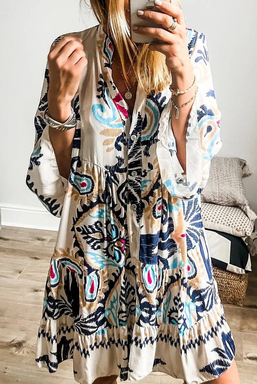 Woman wearing a colorful patterned dress taking a mirror selfie.