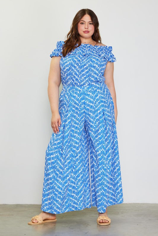 Model wearing blue printed pants and printed shirt to match against a white background