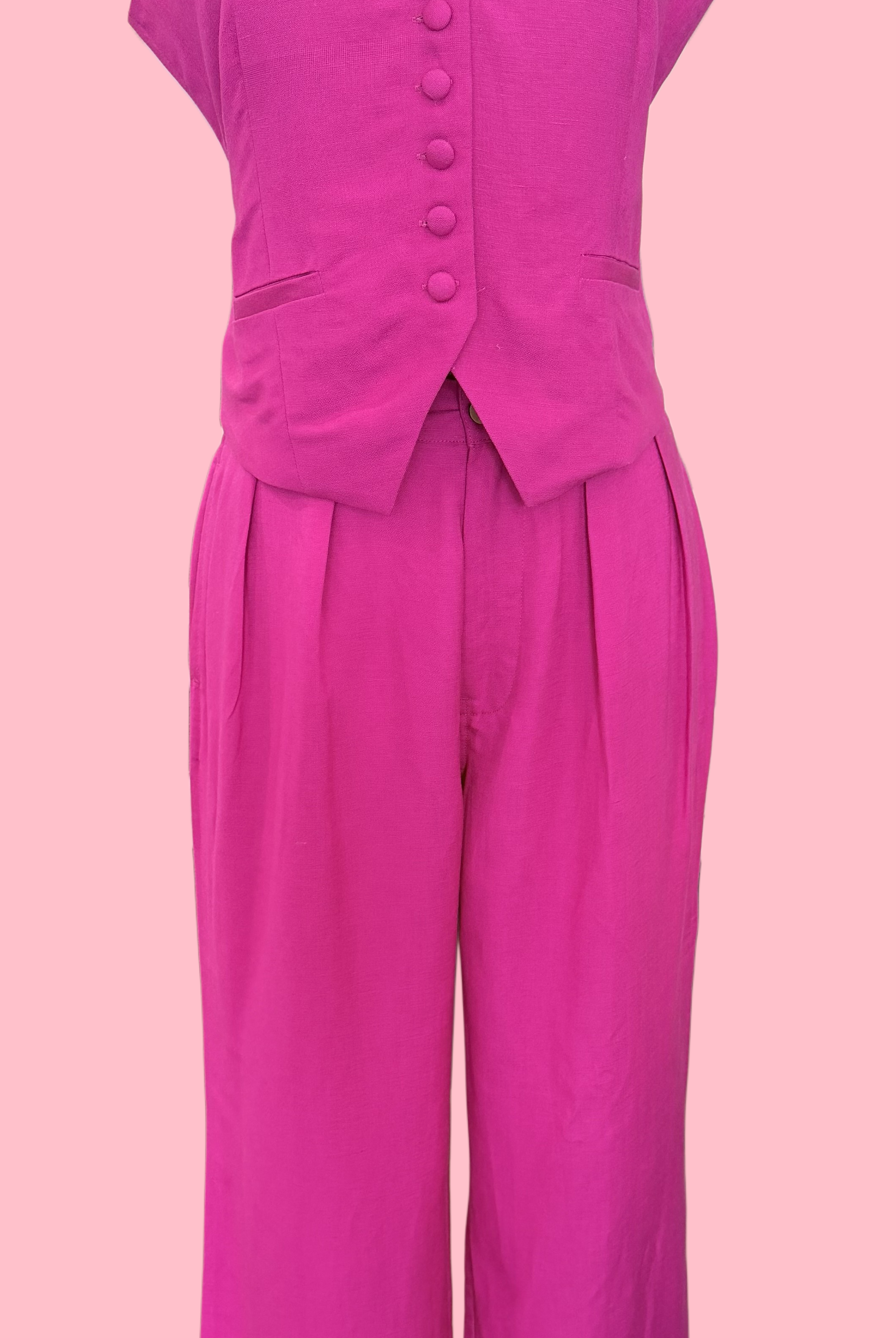 Pink sleeveless top and wide-leg pants on a mannequin against a pink background
