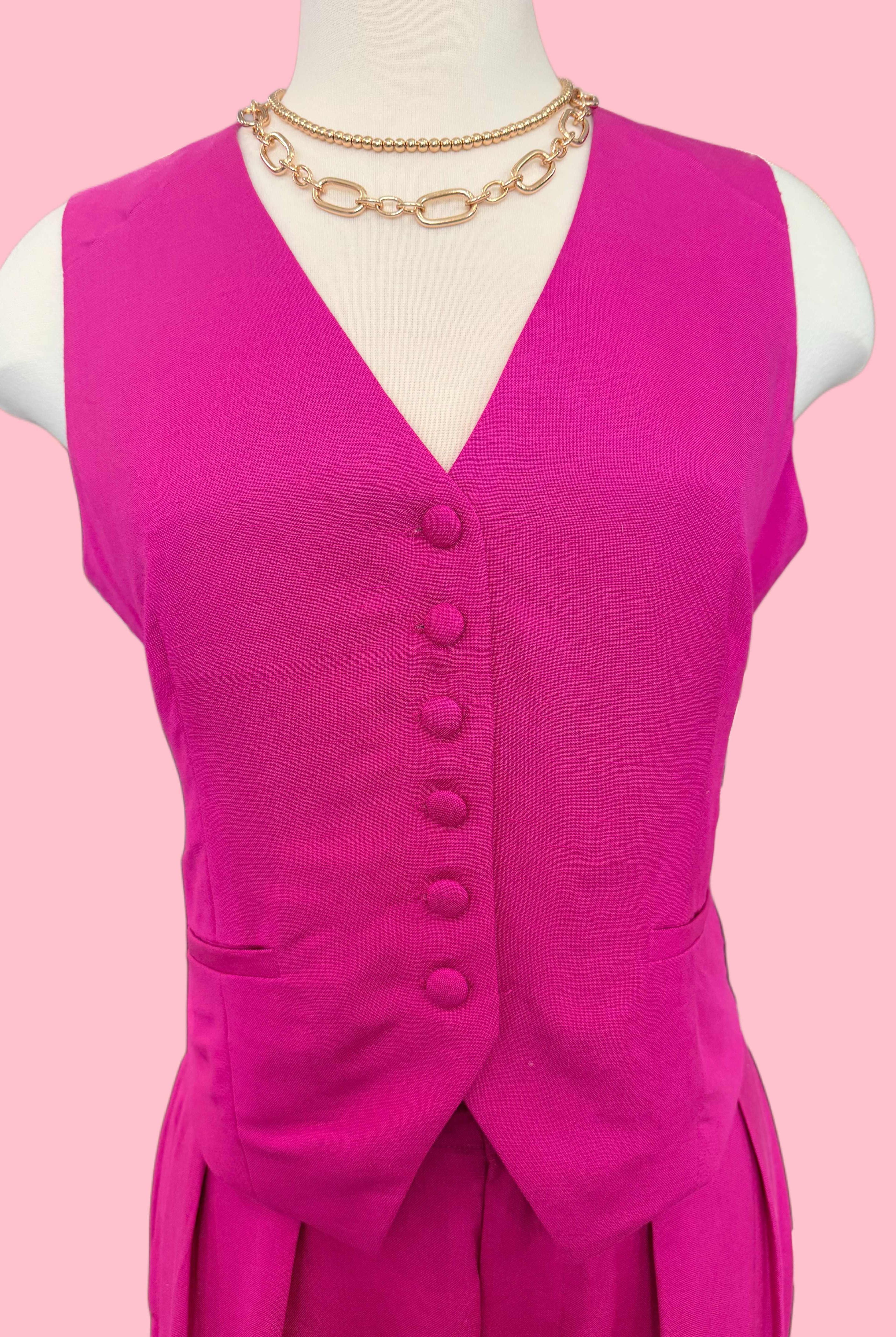 Mannequin wearing a bright pink dress with buttons on a pink background
