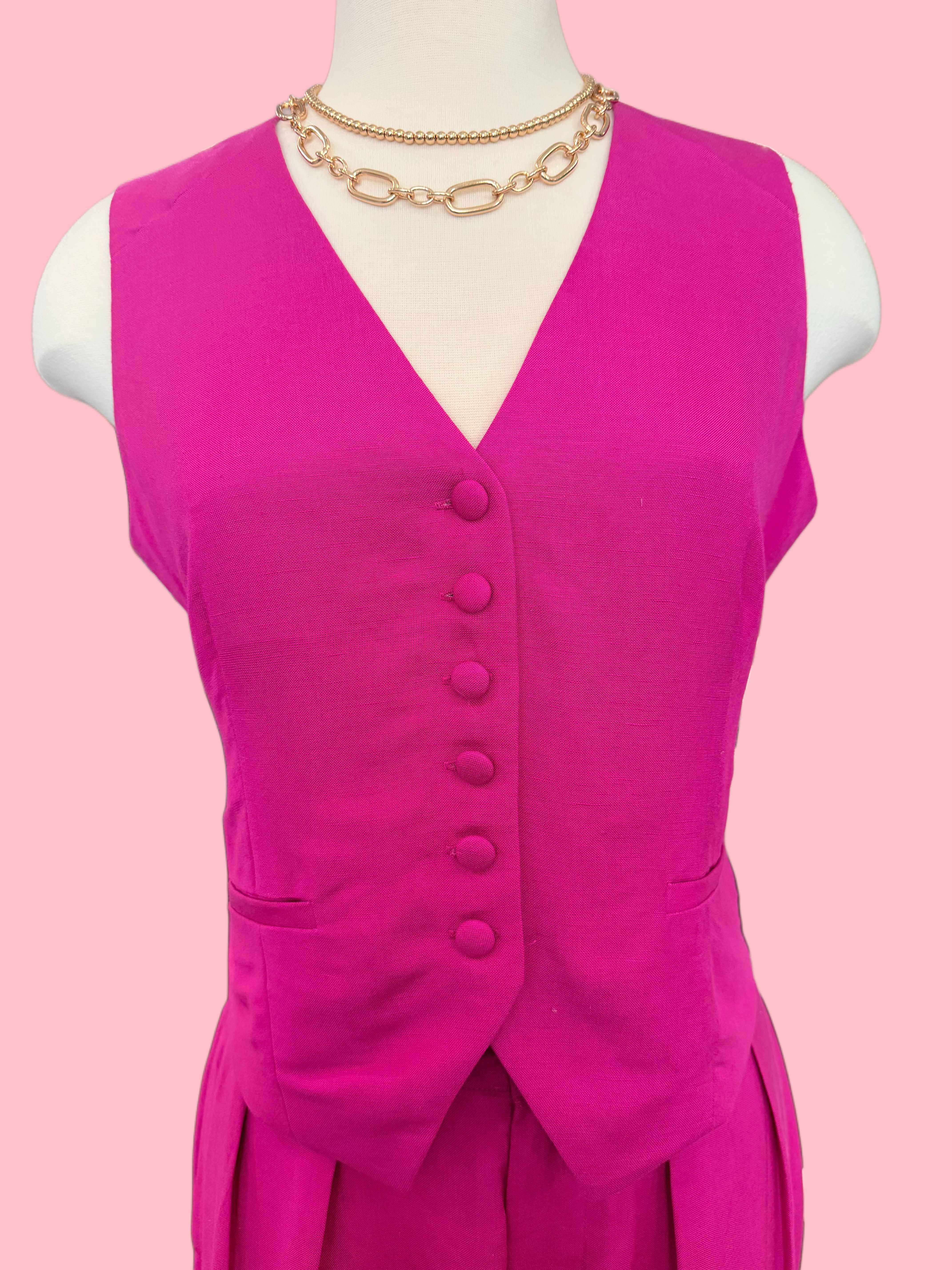 Mannequin wearing a bright pink dress with buttons on a pink background