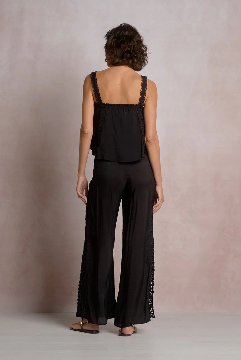The back of woman wearing a black outfit with lace details