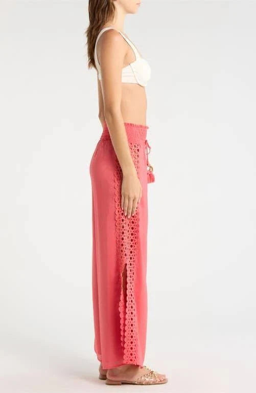 side profile of a woman wearing coral pants with lace details