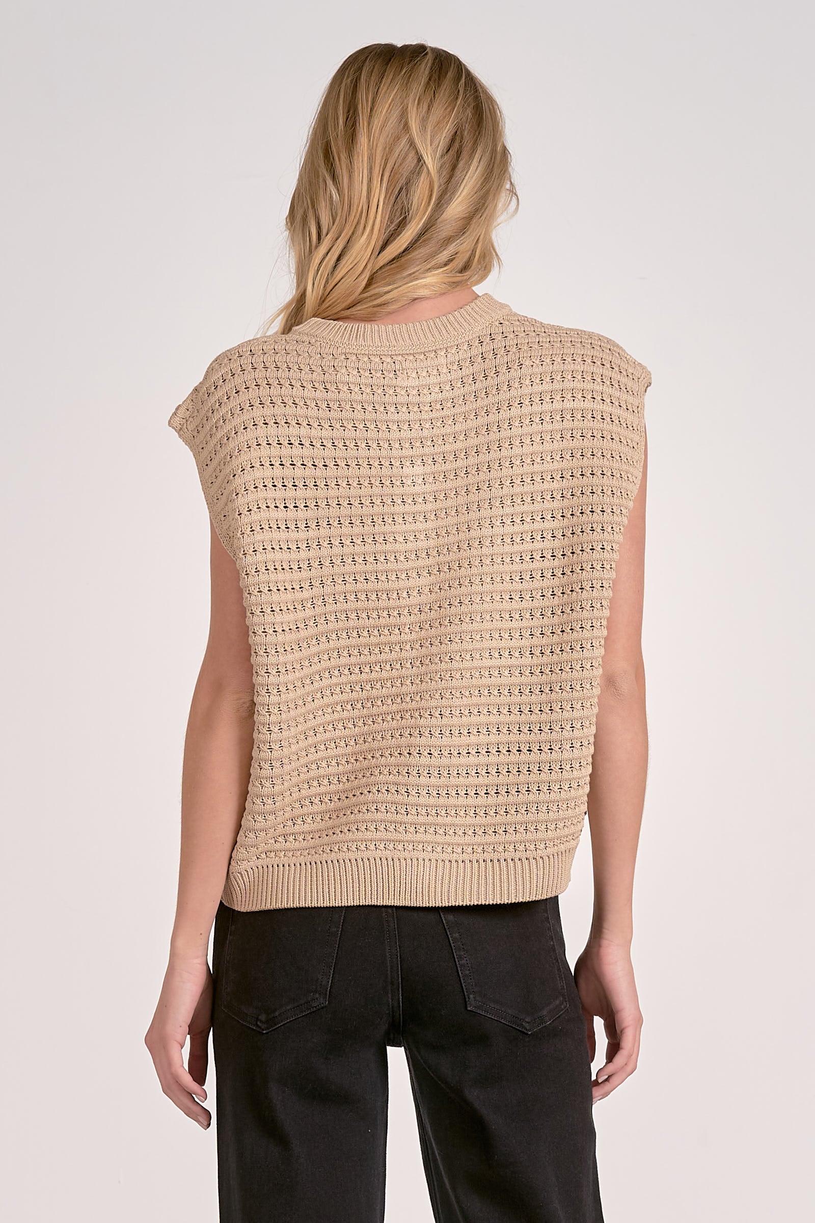 Back of woman wearing a beige knitted vest