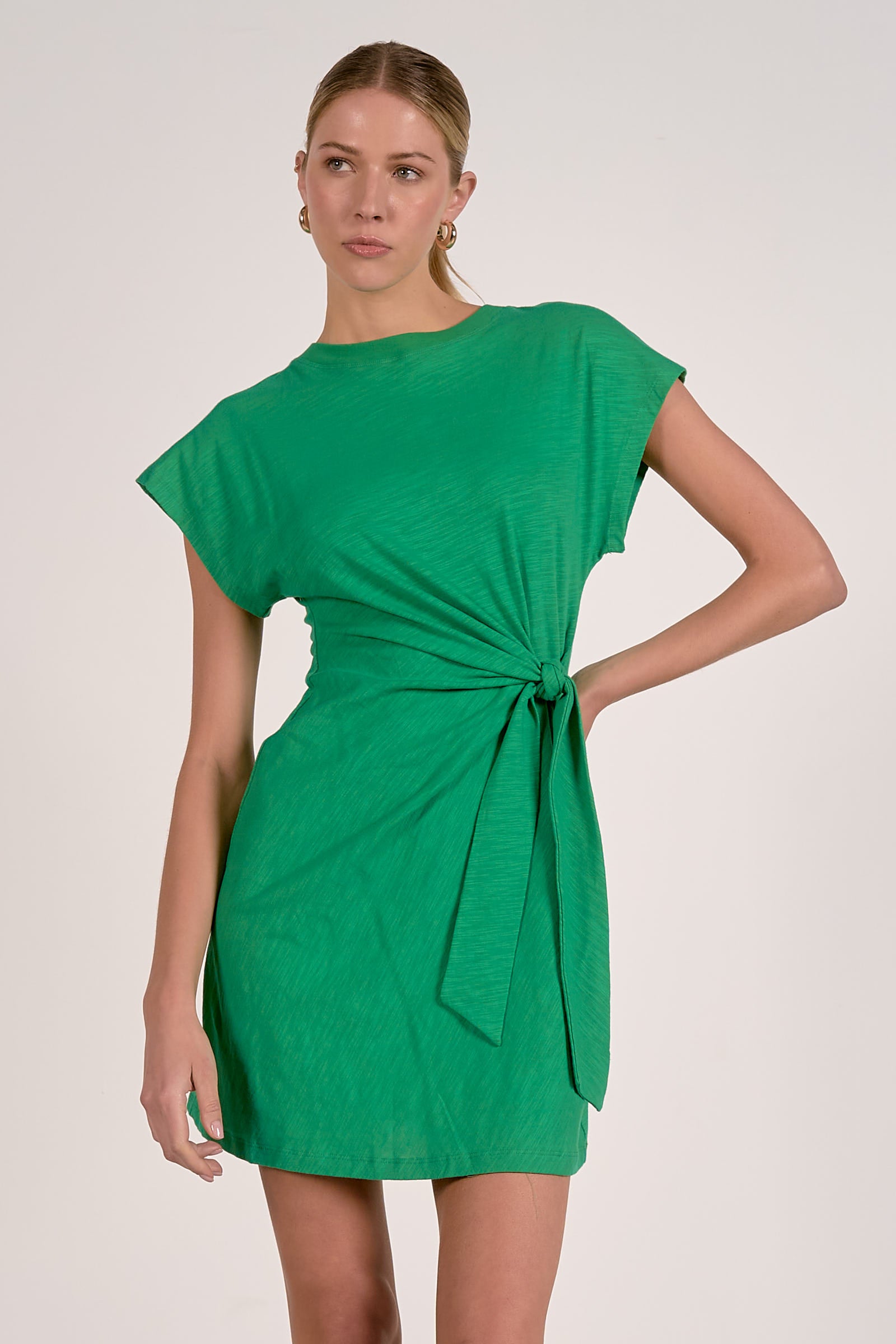 Woman wearing green dress with a tie waist