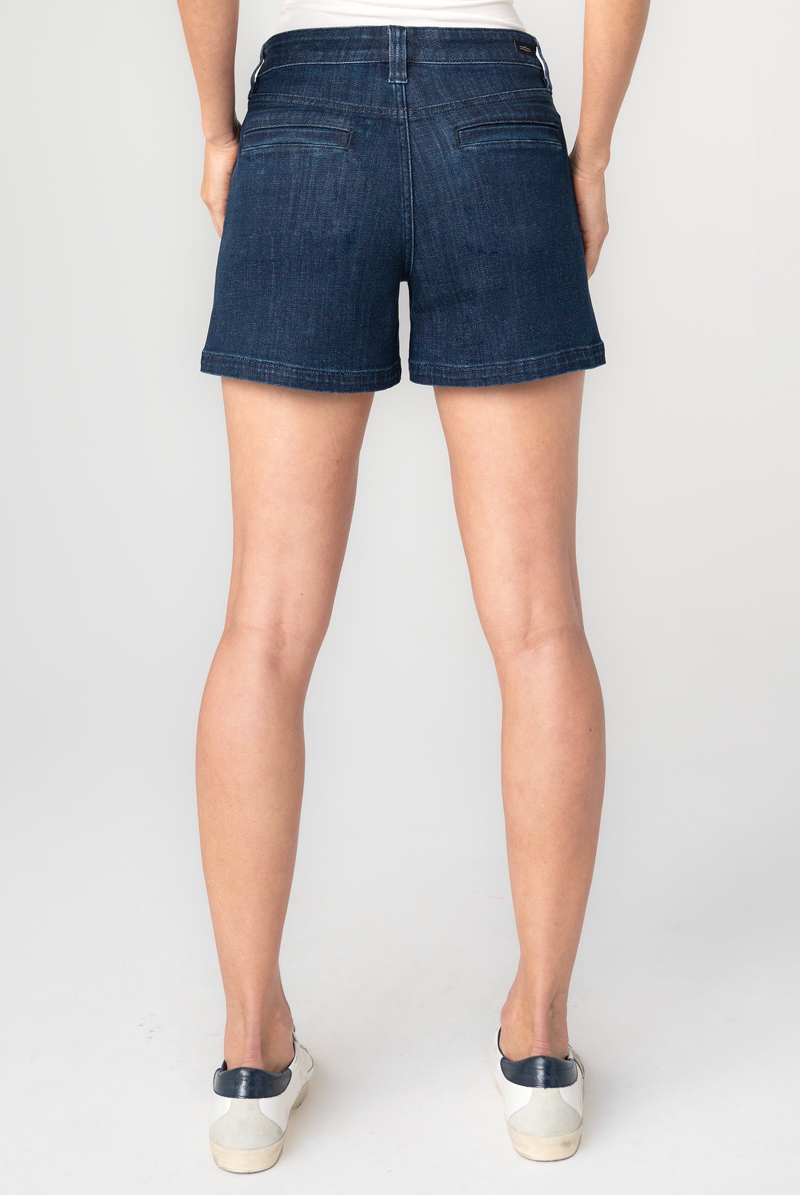 Person wearing dark blue denim shorts
