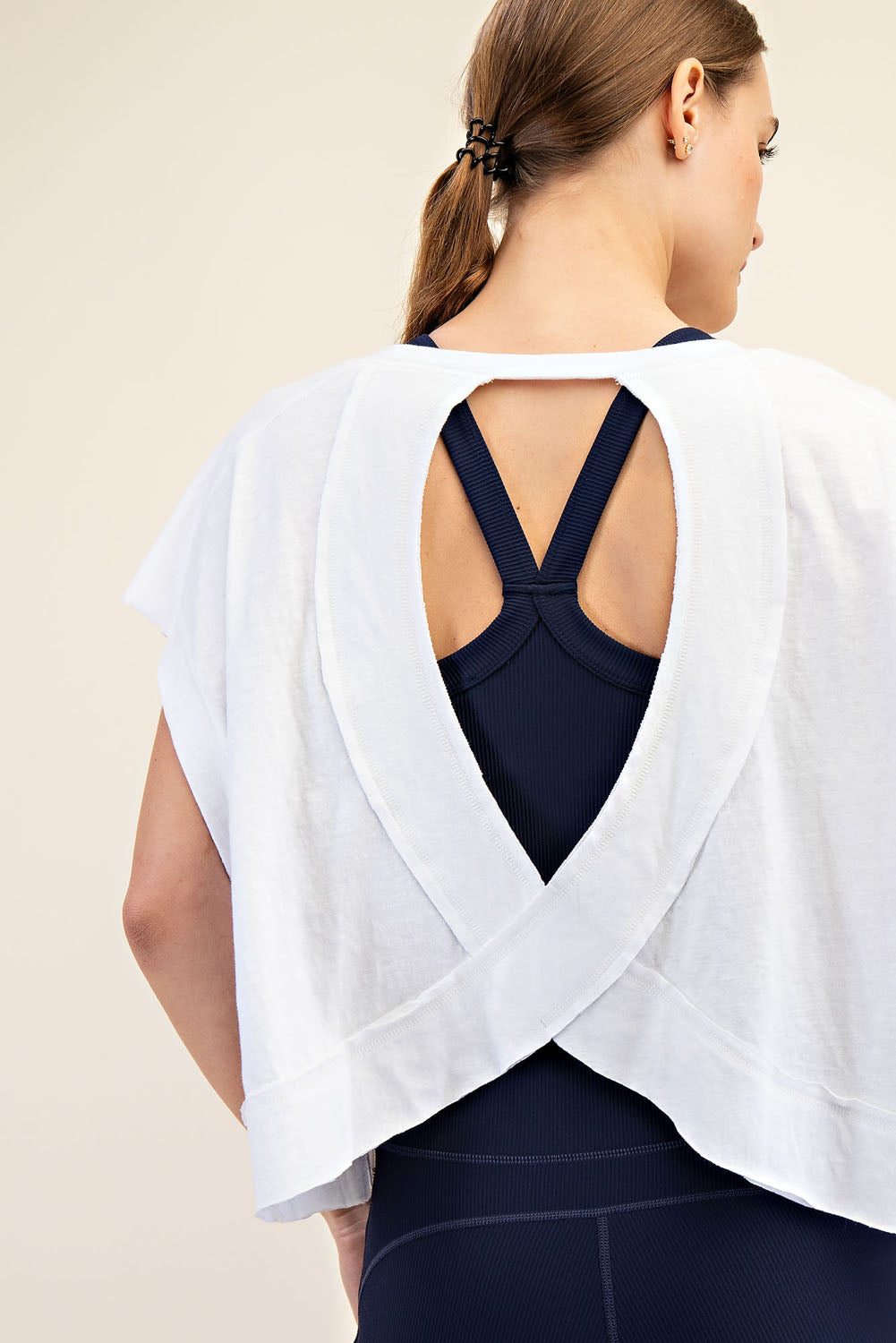 Back of woman wearing a white top with open back 