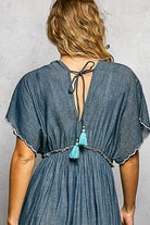 Blue dress with tassels on a gray background