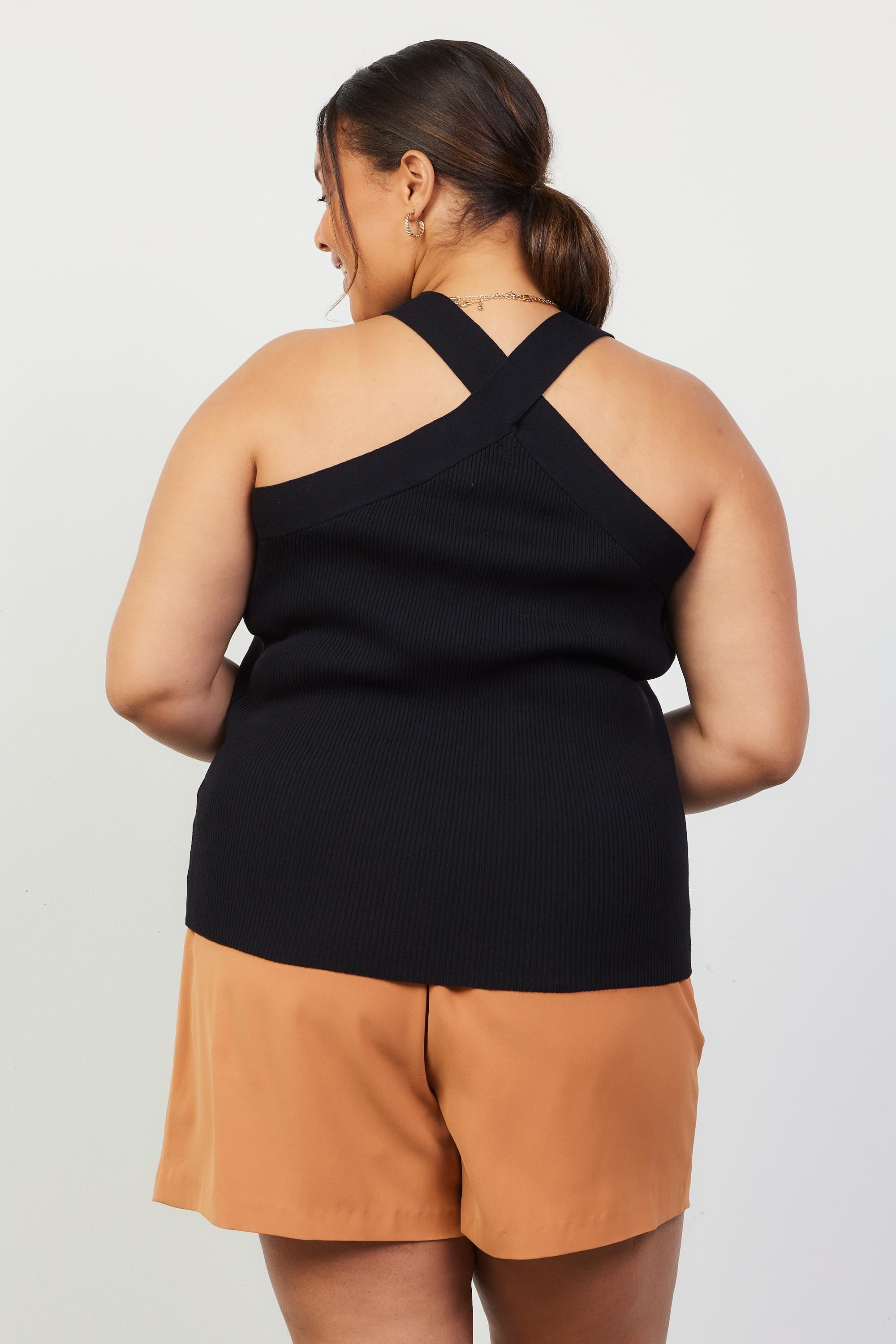 Woman wearing a black sleeveless top with crossed neck 