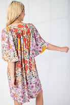 Back of woman wearing floral dress with cape sleeves