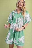 Woman wearing a green floral babydoll dress 