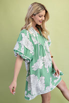Woman wearing a green floral babydoll dress 