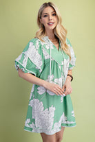 Woman wearing a green floral babydoll dress 