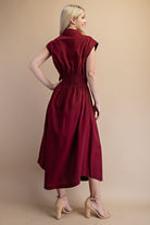 side view of model wearing burgundy dress wearing nude heels