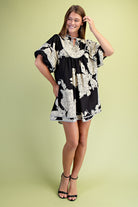 Woman wearing a black and white floral dress with short puff sleeves