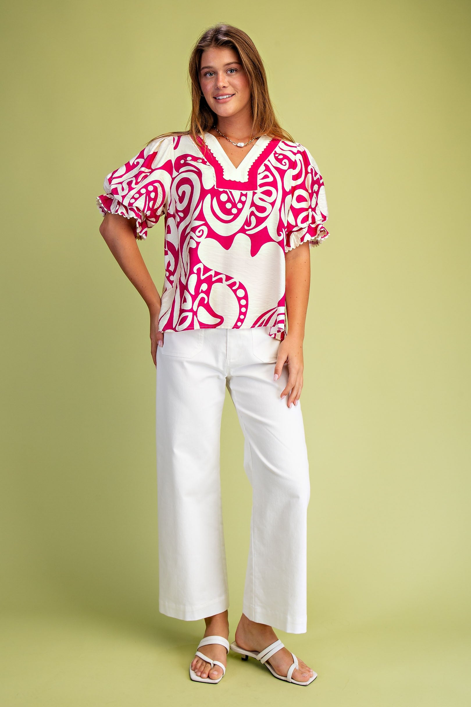 Woman wearing a pink and white patterned blouse with balloon sleeves
