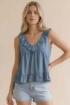 Woman wearing a blue ruffled v neck top 