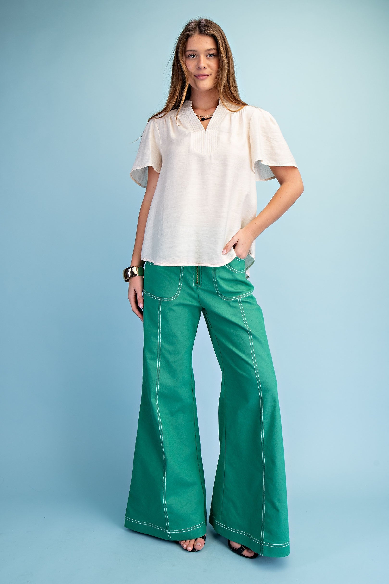 model wearing green pants and white shirt 