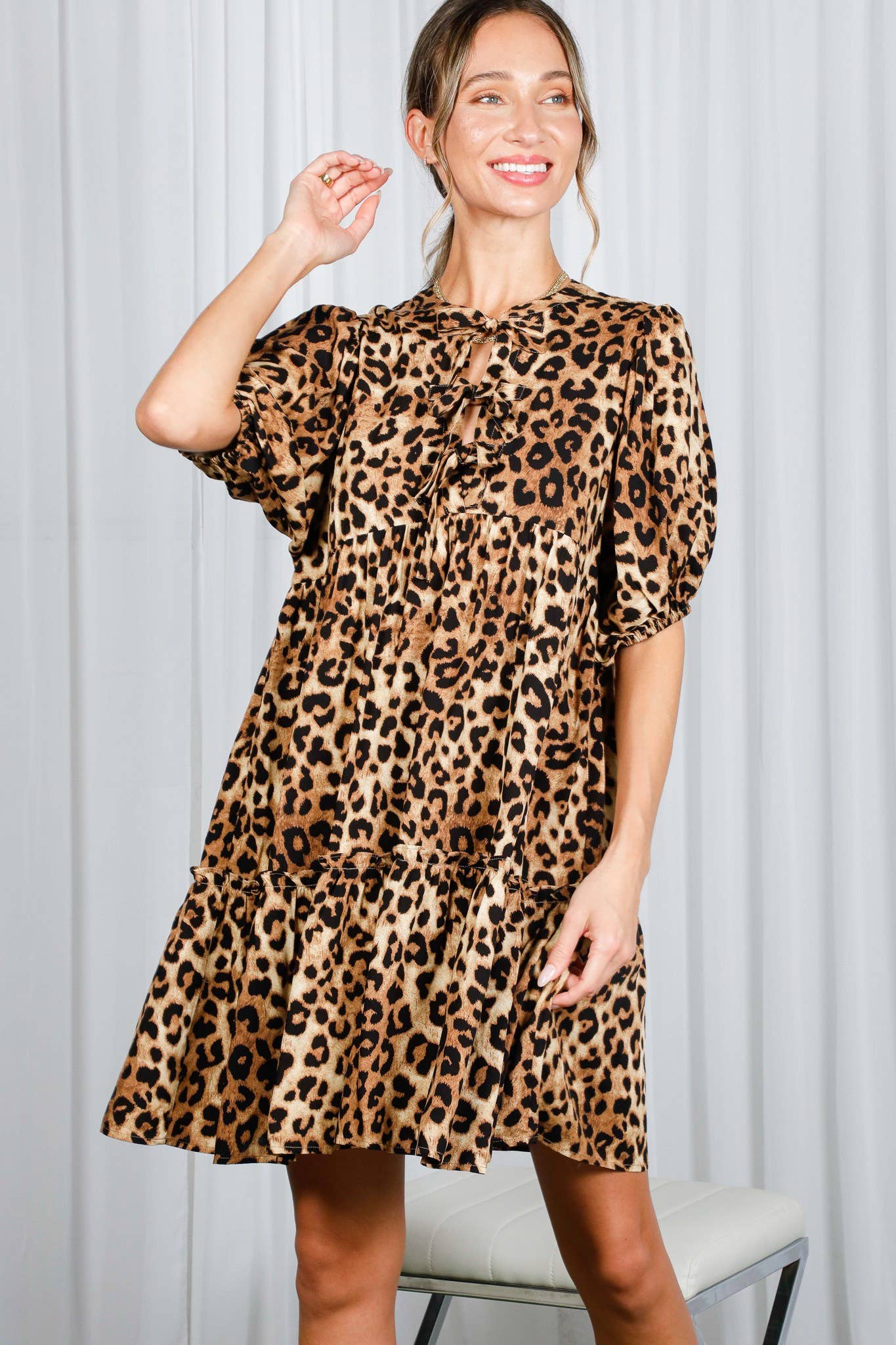 Woman wearing a leopard print dress against a light gray background