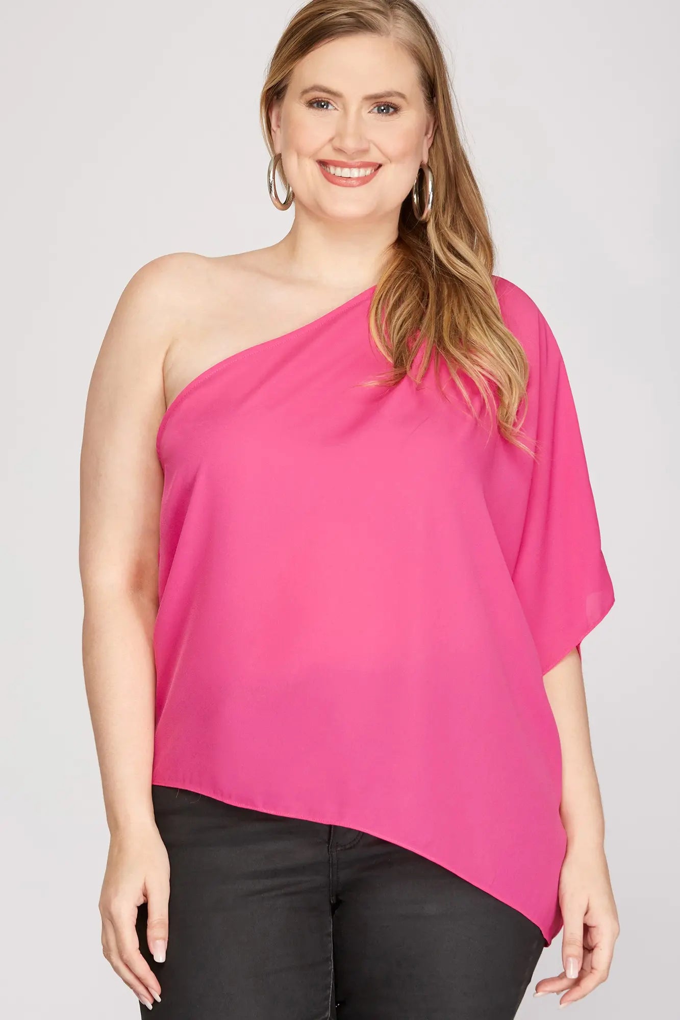 Woman wearing a bright pink one-shoulder top 