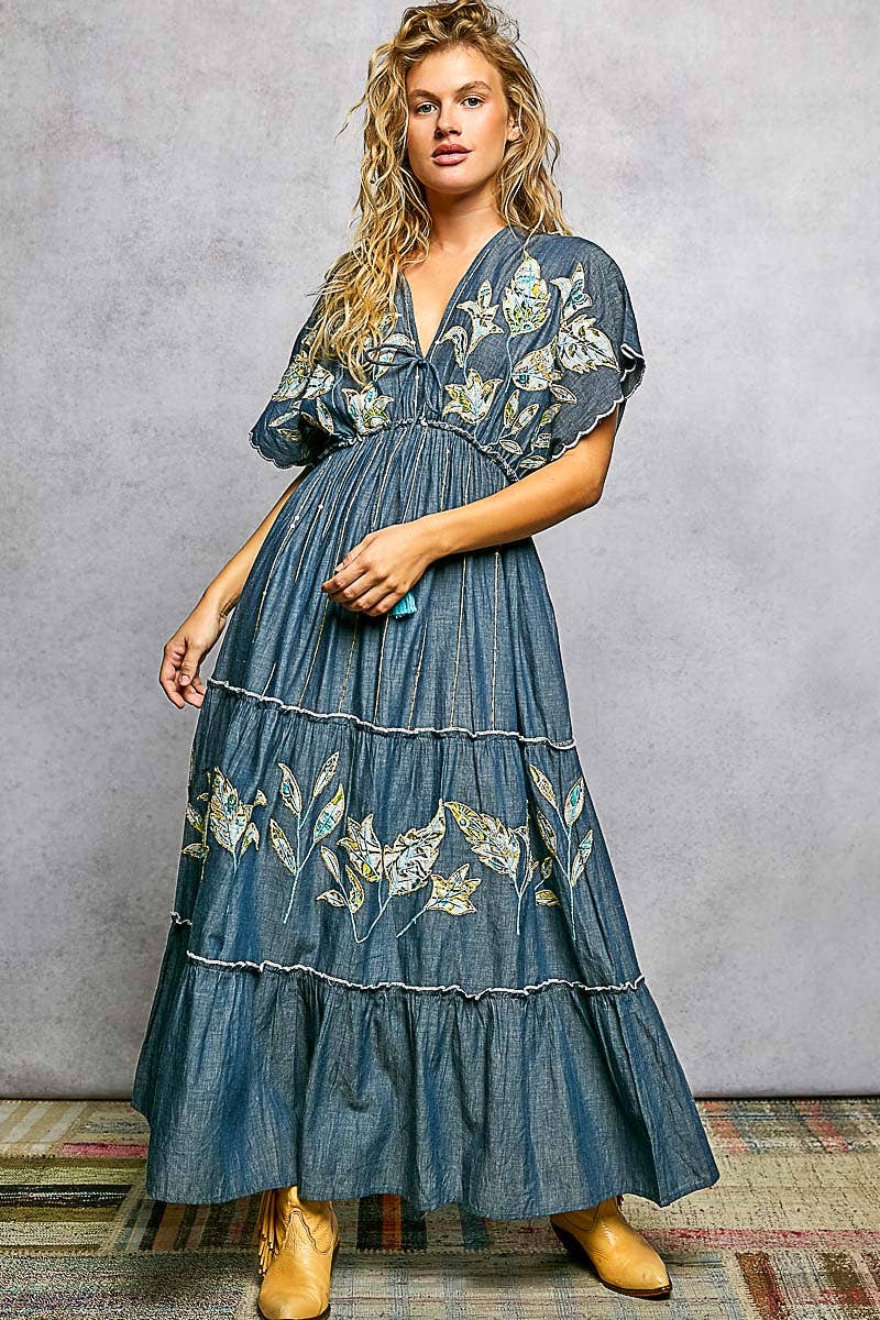 Woman wearing a blue floral dress against a gray background