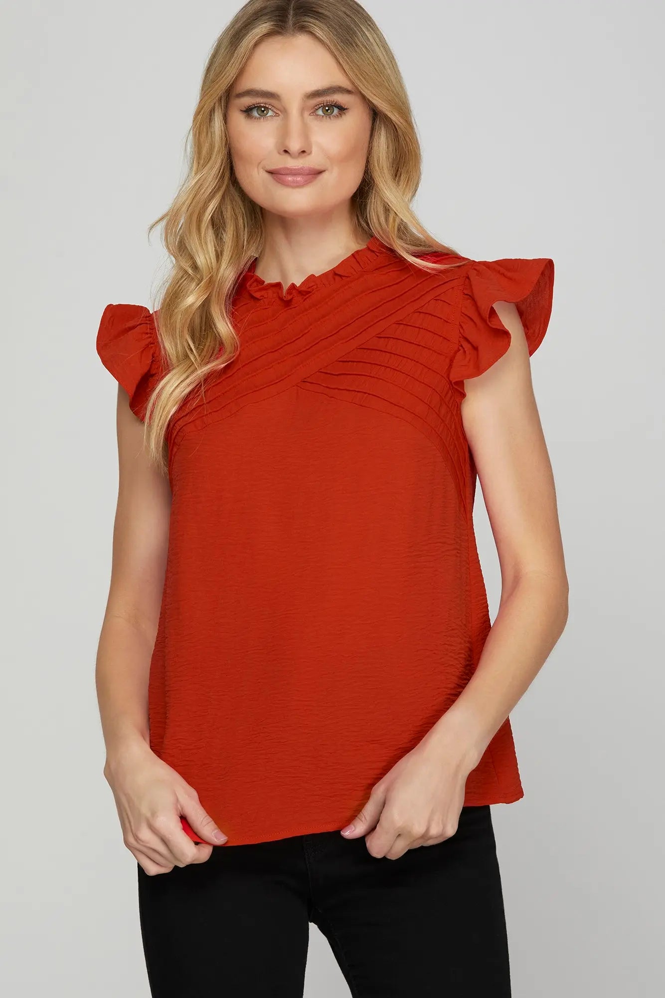 Woman wearing a red blouse with ruffled sleeves